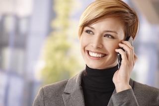 A woman smiles while on the phone | Medina OH Porcelain Veneers