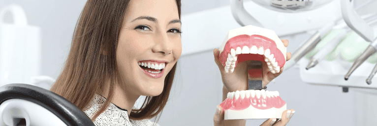 tooth replacement options medina | woman at dentist