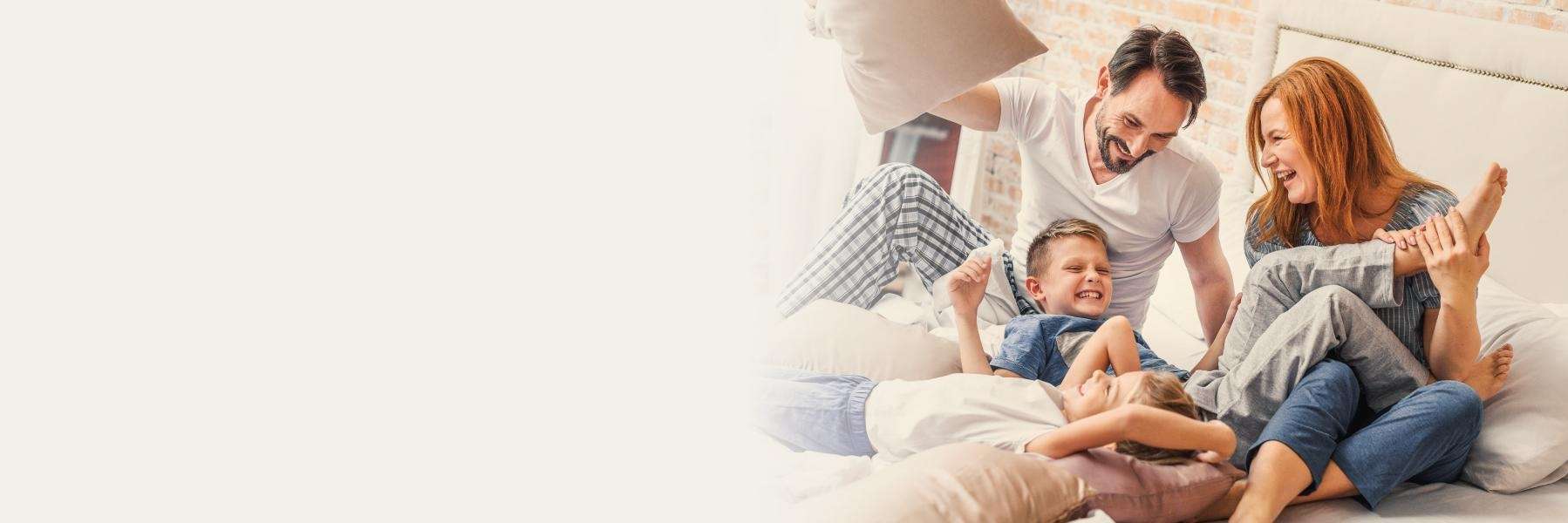 A family playing in bed | dental hygiene Medina