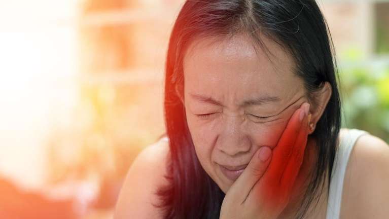 A woman experiencing a dental emergency | dentist Medina OH