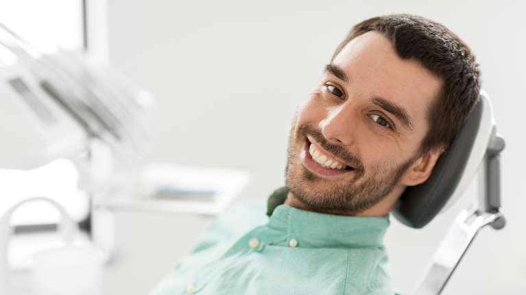 A smiling man in the dentist's chair