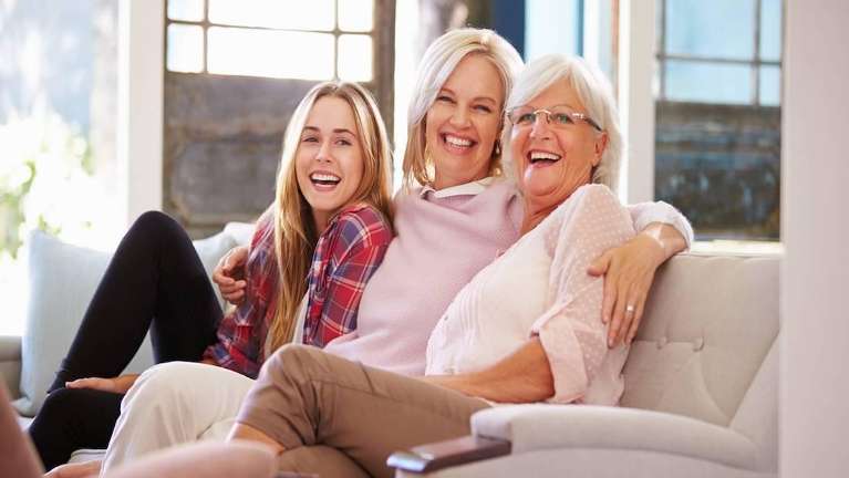 A family laughing on the couch | crowns Medina OH