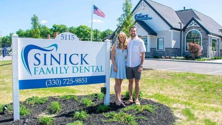 Drs Jessica and Christopher Sinick in front of Sinick Family Dental in Medina Ohio