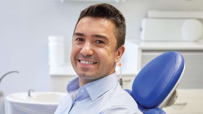 A man smiling in the dentists chair