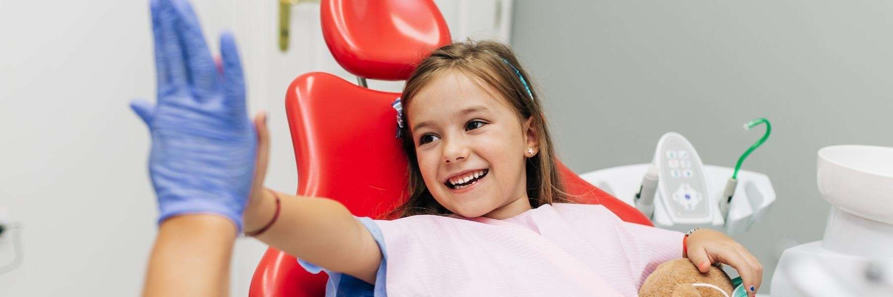 Child high-fiving dentist, showing trust with the top pediatric dentist in Medina.