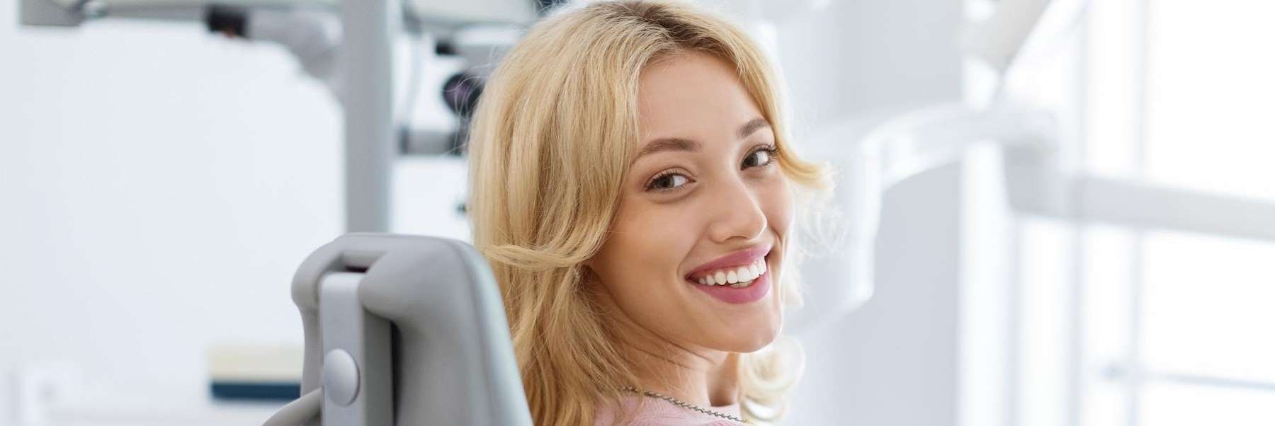 A smiling woman in a dental examination room